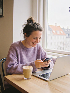 Marketer checking social media trends on her phone at a café